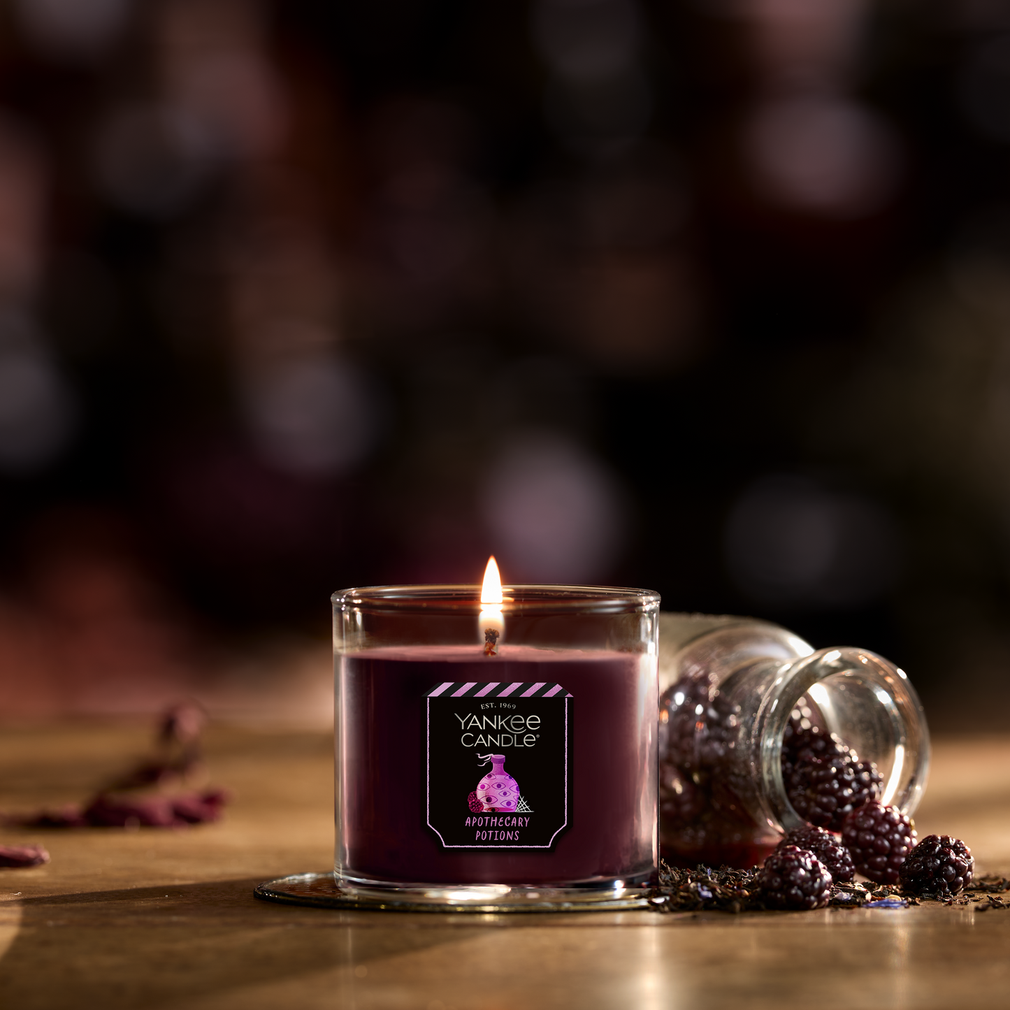 Purple scented candle in glass jar with berries and Apothecary Potions label, cozy home decor ambiance.